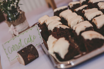 Handwritten sign for carrot cake beside a tray of iced carrot cake