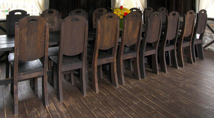 16 wooden chairs at the table in the hall.