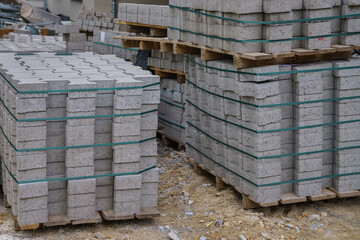 Paving slabs stacked on pallets at a construction site.