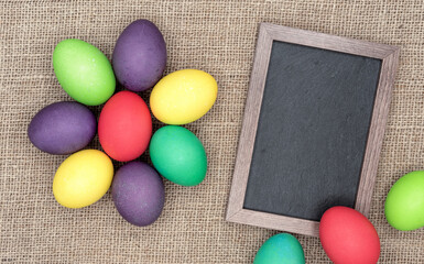Frame with chalk board and multicolored Easter eggs.