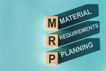 Wooden cubes building word MRP - (Abbreviation of Material requirements planning) on light blue background. - obrazy, fototapety, plakaty