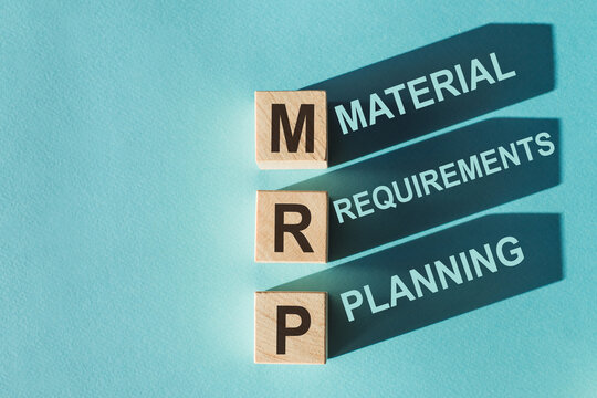 Wooden cubes building word MRP - (Abbreviation of Material requirements planning) on light blue background.