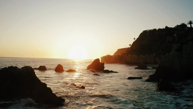 malibu california west coast cliffs beach shore waves sunset backlight sun silhouette aerial drone 4k