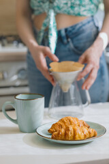 European woman brews coffee at home in her kitchen and enjoys her morning, good morning, caucasian woman makes coffee filter at home and enjoys her day off, woman does internet detox on her day off