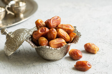 Ramadan palm fruit dates in silver bowl symbolize sacred month for muslims. Ramadan kareem food fasting break concept