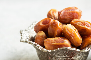 Ramadan palm fruit dates in silver bowl symbolize sacred month for muslims. Ramadan kareem food fasting break concept