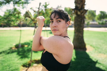 a beautiful white woman with brown hair exercises her arms to be ready for physical activity                  