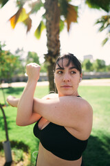a beautiful white woman with brown hair exercises her arms to be ready for physical activity                  