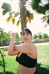 a beautiful white woman with brown hair exercises her arms to be ready for physical activity                  