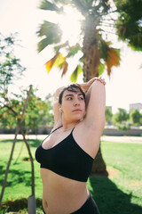 a beautiful white woman with brown hair exercises her arms to be ready for physical activity                  