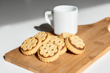 Close-up of very nice cookies filled with chocolate and hazelnut cream. Image of smile shaped cookies with cup of coffee and copy space available.