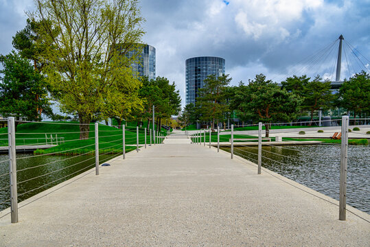 Beautiful footbridge over a calm lake in the green Autostadt park in Wolfsburg, Germany