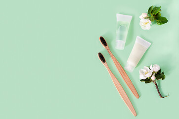 bath accessories zero waste in eco-friendly home, herbal toothpaste, bamboo toothbrush on green...