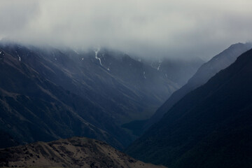 Obraz premium Dark silhouettes of mountains. Dramatic mountain landscape in the clouds. Panoramic rock view.