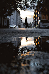Low angle shot of reflection in a puddle on the street after the rain © Lukas Knobloch/Wirestock