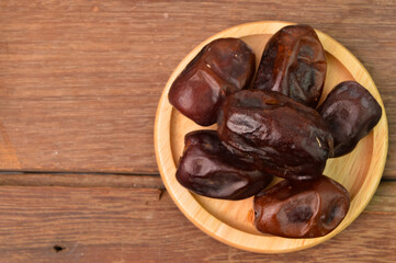 Bunch of dates on wooden plate. Top view.