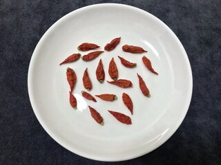 The picture of dried red chilies on white plate