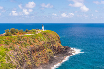 Scenic lighthouse on edge of cliff near calm tropical ocean