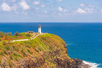 Fototapeta na wymiar Lighthouse on tropical coast with tourists and blue ocean