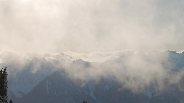 Panoramic View of Canadian Nature Landscape on top of snow covered mountain and green trees in spring. Taken on a snowshoe hike up Elfin Lake in Squamish, North of Vancouver, BC, Canada.