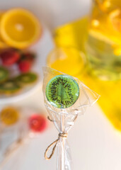 Sugar-free lollipops with dry fruit inside on a background with fresh juicy fruits. Healthy sweetness, benefits of natural fruits