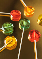 Sugar-free fruit lollipop on a minimalistic background in yellow tones. Healthy sweetness with dry...