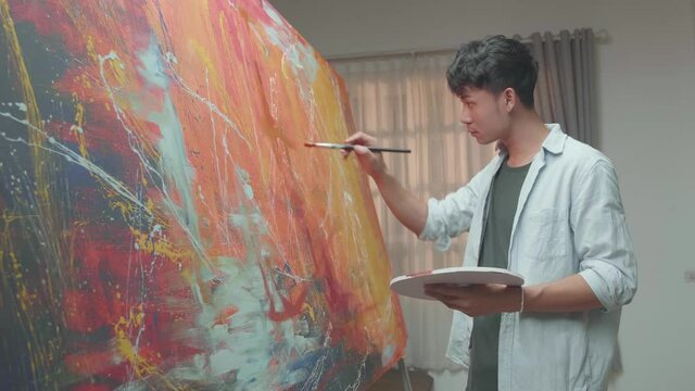 Asian Man Working On Abstract Painting
