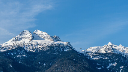 Fototapeta na wymiar Beautiful snow-capped Columbia Mountains against the blue sky in British Columbia Canada