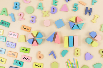 Multicolored wooden fractions, cubes, numbers on wooden table. Trendy puzzle toys. Geometric shapes. Back to school. Educational toys for kindergarten, preschool or daycare. Close up.