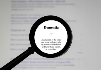Selective focus on word dementia, word in a dictionary. Close up of an English dictionary page with the word dementia