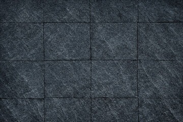 Dark grey black slate stone wall background or texture.