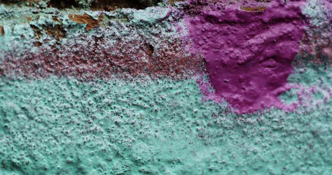 Pan right shot of an old, chipped paint on a wall. 