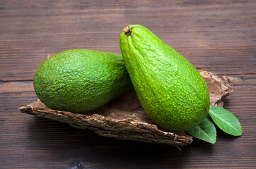 two avocado fruits on woody background