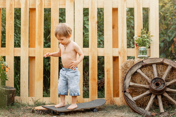 Pretty cheerful young boy. Cute little child are skateboarding outdoors. A boy training inline...