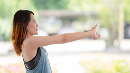 Beautiful Asian woman in sports outfits doing stretching before workouts at hot during COVID-19 pandemic to keep a healthy life. Healthy young woman stretching and warming up to workouts