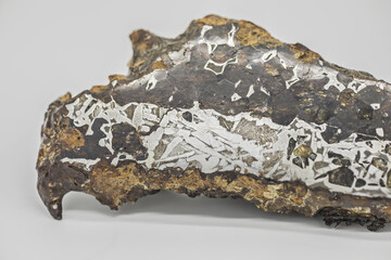 Closeup of real piece of iron meteorite with visible Widmanstatten texture and pattern on white background  © Katrin