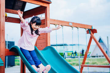 滑り台で遊ぶ小さな女の子