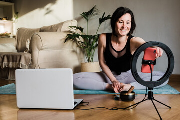Yoga teacher streaming online class for webinar masterclass lesson with mobile phone at home -...