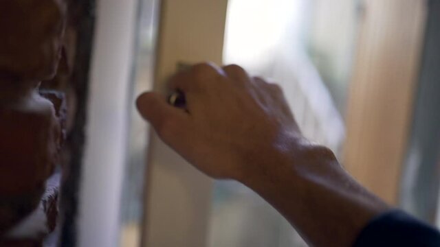 Person opening home window. Close-up hand opens knob