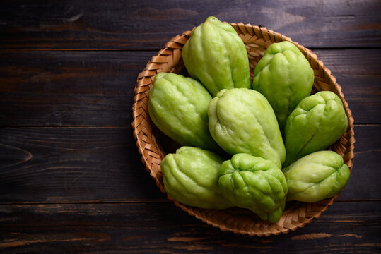 Chayote squash fruit (Mirliton, pipinola or choko) in a basket on wooden background, Edible fruit eaten both cooked and raw such as salad or salsa