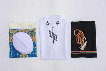 Flat lay and top view of Muslim traditional dress and accessories for praying with praying beads