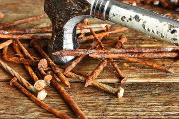 A close up image of old rusted nails and old construction hammer. 