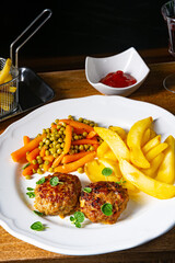 Homemade meatballs with french fries and vegetables