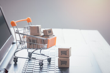 Boxes in a trolley Shopping cart  with laptop keyboard. online shopping Idea, shopping at home,...