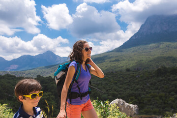 A woman with a backpack goes on a hike with a child