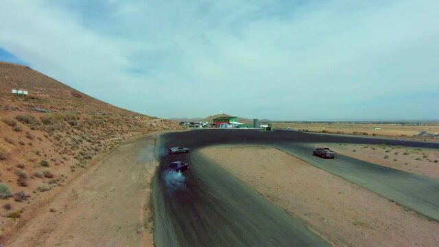 Drift cars swerve around turns at the racetrack showing amazing skill - aerial view