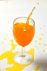A dice falling into a glass of orange liquid caused a splash