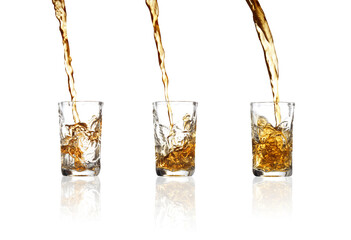Pouring whiskey into shot glass on white background