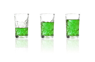 Green liquor into shot glass on white background, Absinthe in shotglass