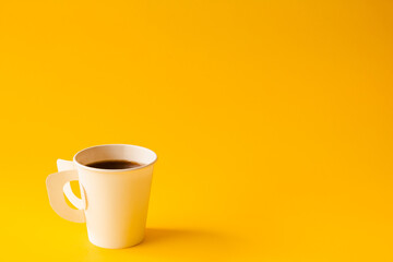 Hot Coffee cup on yellow paper minimal style copy space for your text